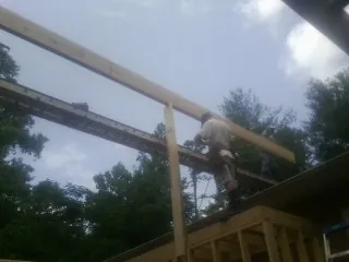 Carpenter setting a ridge beam over a new addition frame — Ice Dam Removal by Roofing Brothers in Eastlake