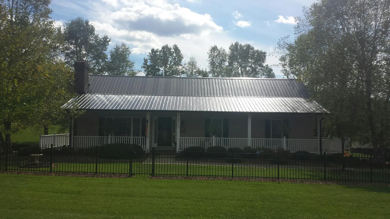 Gray metal roof on a brick ranch with a full width front porch — Gutter Guard Installation work by our crew in Eastlake