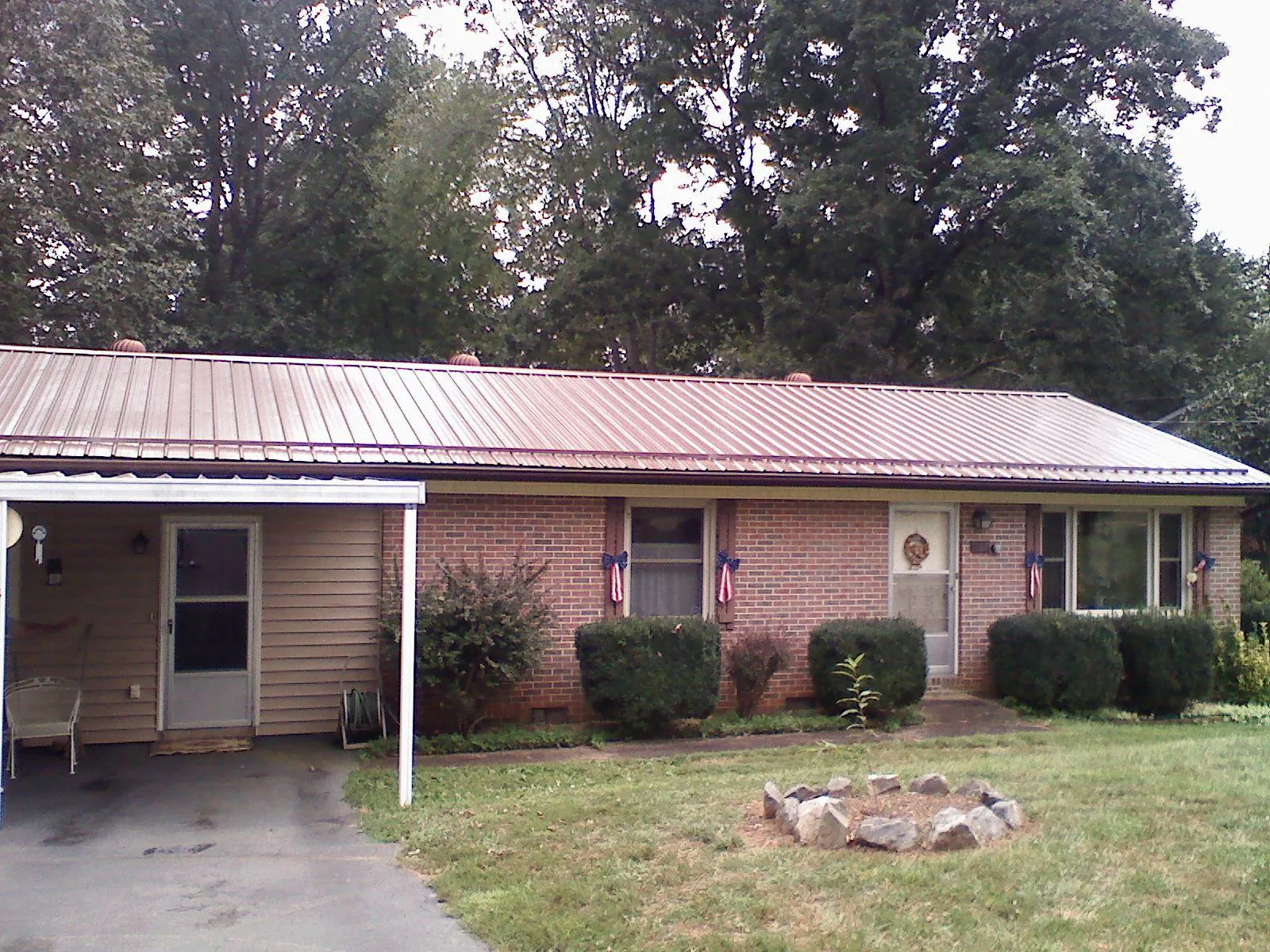 Bronze metal roof and carport on a brick ranch home — Roof Repair work by our crew in Eastlake
